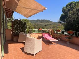 eine Terrasse mit Stühlen, einem Tisch und einer Bank in der Unterkunft OnlyOne in Scandicci
