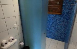 a bathroom with a blue shower stall with toilet paper at Hotel Vila Marola in Taíba +51 photos