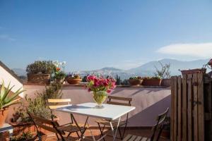 a table and chairs with a vase of flowers on a balcony at L'Attico Affittacamere in Santa Maria degli Angeli