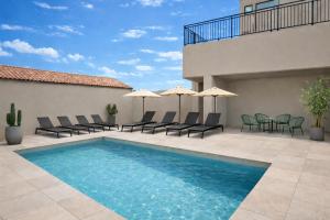 a swimming pool with chairs and umbrellas on a patio at Résidence Saint Flor in Saint-Florent
