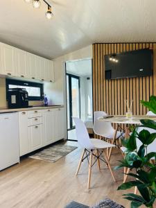 eine Küche und ein Esszimmer mit Tisch und Stühlen in der Unterkunft Tiny House Doi Frați in Drăguş