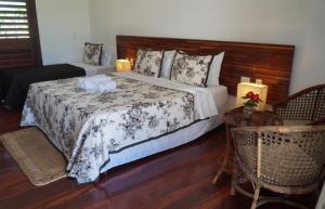 a bedroom with a large bed with a wooden headboard at Hotel Vila Marola in Taíba