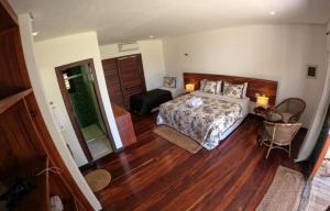 a bedroom with a bed and a living room at Hotel Vila Marola in Taíba