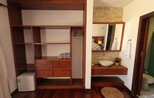 a bathroom with a sink and a vanity with a mirror at Hotel Vila Marola in Taíba