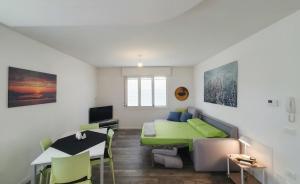 a small room with a bed and a desk and a table at Myhouse Apartment in Cervignano del Friuli