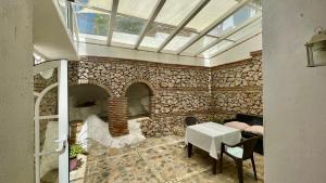 a room with a stone wall with a table and chairs at La Casa Turquesa in Frigiliana