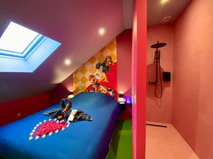 a childs bedroom with a blue bed and a window at Retro Gaming Mood - Arcade Games - Jacuzzi - Sauna - Switch 2 in Courcelles