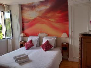 a bedroom with a bed with a painting on the wall at Villa Do Sol Chambre d'Hôtes "La Dune" in Arcachon