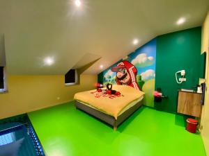 a bedroom with a green floor and a bed with a painting at Retro Gaming Mood - Arcade Games - Jacuzzi - Sauna - Switch 2 in Courcelles +42 photos