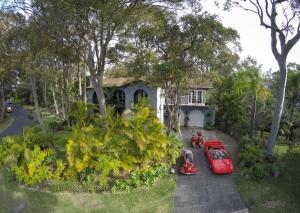 due auto rosse parcheggiate di fronte a una casa di Palm Beach Bed & Breakfast a Palm Beach