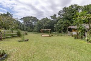 a large yard with a gazebo and a fence at Recanto Aconchego in Torres