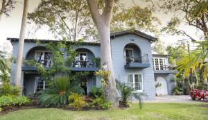 una casa con un árbol delante de ella en Palm Beach Bed & Breakfast en Palm Beach
