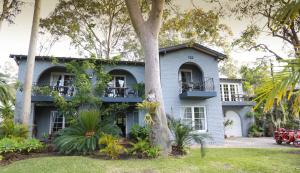 a house with a tree in front of it at Palm Beach Bed & Breakfast in Palm Beach