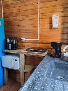 a kitchen with a stove and a counter top at Treehouse albatroz hospedaria in Imbituba