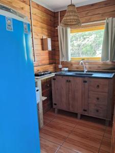a kitchen with wooden walls and a sink and a window at Treehouse albatroz hospedaria in Imbituba +25 photos