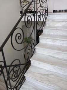 a staircase with white marble stairs and a black railing at Villa Do Sol Chambre d'Hôtes "Les Pins" in Arcachon +3 photos
