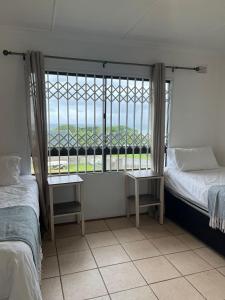 a room with two beds and a large window at Hawthorne By The Sea in Kingsborough
