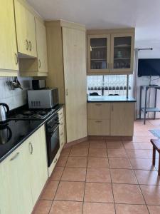 a kitchen with wooden cabinets and a tile floor at Hawthorne By The Sea in Kingsborough