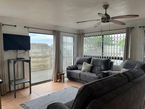 a living room with a couch and a ceiling fan at Hawthorne By The Sea in Kingsborough