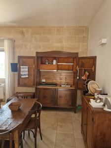 a kitchen with wooden cabinets and a wooden table at Sassi e Virtù in Matera