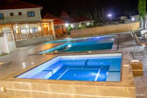 ein großer Swimmingpool in einem Garten bei Nacht in der Unterkunft Rainforest Hotel in Odumasi