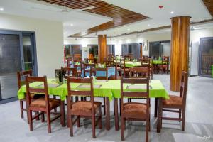 ein Esszimmer mit grünen Tischen und Stühlen in der Unterkunft Rainforest Hotel in Odumasi