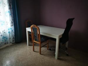 a white desk with two chairs and a table and a curtain at Stadtmitte Ferienwohnung in Darmstadt