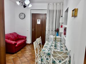 a living room with a table and a red couch at Paloma nel bosco in Sutri +10 photos