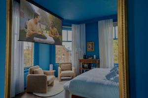 a bedroom with a tv hanging on a blue wall at Hotel By Atelier in Nijmegen