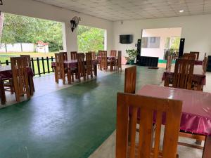a dining room with tables and wooden chairs at Royal Garden in Dambulla