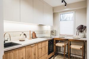 a kitchen with wooden cabinets and a sink and a window at Filomacka Przestrzeń in Toruń