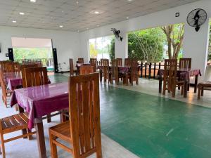 a dining room with tables and chairs and a clock at Royal Garden in Dambulla