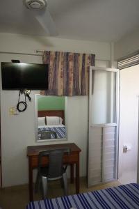 a bedroom with a desk and a bed and a mirror at Hotel Reforma in Veracruz
