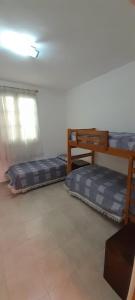 a room with two bunk beds and a window at Casa 7 personas in Villa Gesell
