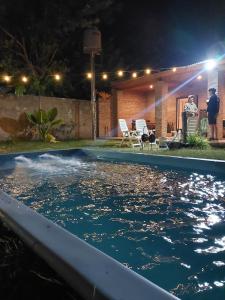 a swimming pool at night with people in a backyard at La posadita sp in San Pedro