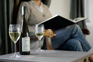 a bottle of wine and two glasses on a table at Das Weinberghaus in Fellbach