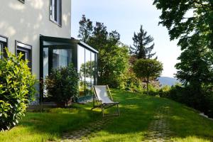 a chair sitting in the grass next to a house at Das Weinberghaus in Fellbach