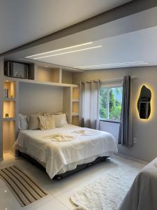 a bedroom with a large bed and a window at Boutique House - Ilha Grande in Abraão