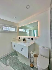 a bathroom with a sink and a toilet and a mirror at Arlington Beach House - by Yale in West Haven