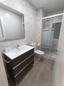 a bathroom with a sink and a toilet and a mirror at VUT Montse in Alcañiz