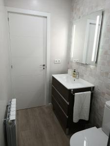 a bathroom with a sink and a toilet and a mirror at VUT Montse in Alcañiz