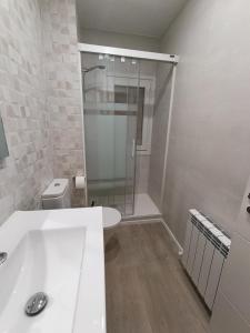 a bathroom with a shower and a white tub at VUT Montse in Alcañiz