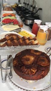 a table topped with different types of bread and pastries at Pousada Pergentino in Maceió