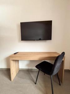 a desk with a television on a wall with a chair at 6444 Apartment in Unterlängenfeld