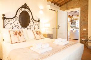 a bedroom with a large white bed with two towels at Chille in Capannori +128 photos