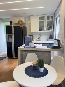 a kitchen with a table and chairs and a refrigerator at Boutique House - Ilha Grande in Abraão