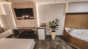 a room with a kitchen and a table and a tub at Paris Motel in Matão +13 photos