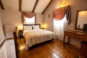 a bedroom with a bed and a desk and a mirror at Georgio's V Chalet Kalavrita in Kalavrita
