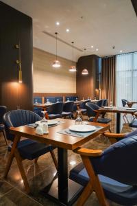 a restaurant with a wooden table and chairs at Hills Managed by Dedeman in Erbil +35 photos