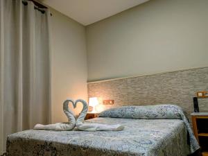 ein Schlafzimmer mit zwei Betten, die mit Herzen verziert sind in der Unterkunft Alojamientos ALBOR I in Gijón